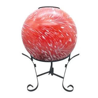 Red and white solar LED glass gazing ball on black metal stand with swirled design.