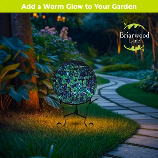Geometric blue solar LED glass gazing ball on stand in garden with pathway and greenery around.