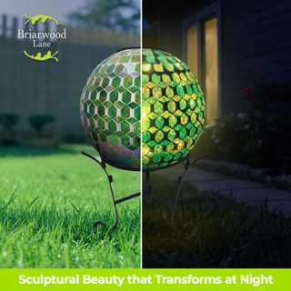 Green and purple solar LED glass gazing ball with mosaic pattern on stand outdoors day and night.