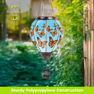 Briarwood Lane solar lantern with orange butterflies and blue glass, hanging outdoors from a chain.