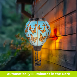 Butterflies Solar Balloon Lantern, solar powered lantern with hanging butterflies design glowing on wooden wall.