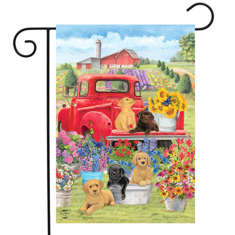 Briarwood Lane Spring Day Puppies garden flag with colorful dogs and flowers on a mini decorative display.
