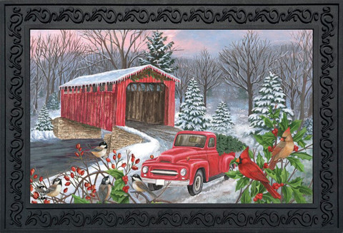 Briarwood Lane Winter Covered Bridge doormat with red truck, cardinals, and holly on snowy scene.