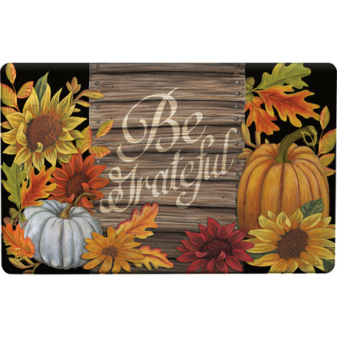 Briarwood Lane Be Grateful Comfort Mat with fall leaves, pumpkins, and sunflowers on wooden background.