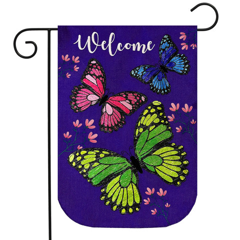 Briarwood Lane purple garden flag with colorful butterflies and Welcome text on burlap material outdoors.
