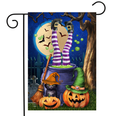 Witches Brew Garden Flag with legs in cauldron, pumpkins, and witch hat on Halloween night.