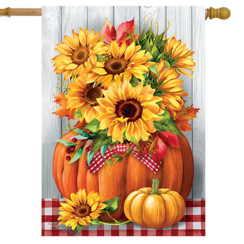 Sunflowers in Pumpkin House Flag with red and white ribbon on a wooden background with tablecloth.