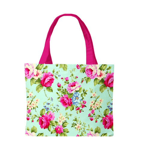 Spring Floral Canvas Tote bag with pink handles and colorful floral print on light green background.