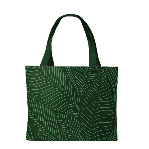 Dark green canvas tote bag with white tropical leaf pattern and two sturdy handles visible.