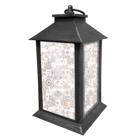 Distressed black metal lantern with white and gold patterned glass panels and roof handle.