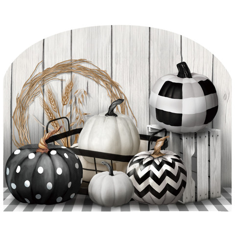 Black and white pumpkins in various patterns on a tray with a wheat wreath nearby.