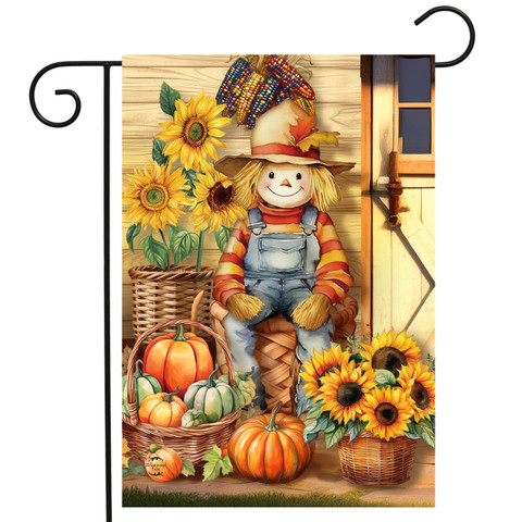 Scarecrow garden flag with sunflowers, pumpkins, and basket, featuring a smiling scarecrow in overalls.