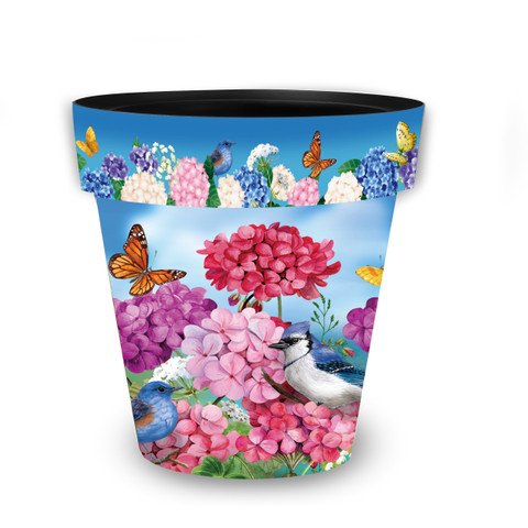 Vibrant medium planter with colorful geraniums, butterflies, and bird amidst pink, purple, and blue hydrangeas.