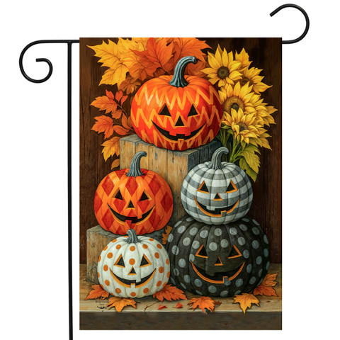 Patterned Pumpkin Patch Garden Flag with four carved jack-o-lanterns and fall leaves and sunflowers.