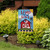 Briarwood Lane patriotic garden flag with red barn, stars, stripes, and "Land That I Love" text.