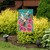 Briarwood Lane small printed spring garden flag with colorful hummingbirds and flowers on a porch stand.