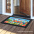 Briarwood Lane 5 O'clock Parrot colorful doormat with umbrella, sun, and parrots on a porch.
