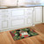 Briarwood Lane Holiday Bird Gathering doormat with cardinal on a kitchen floor with white cabinets.