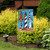Briarwood Lane Lighthouses Summer Garden Flag on a lawn with vibrant plants and sunny display.