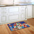 Briarwood Lane Patriotic doormat with floral arrangement and American flag on rustic indoor outdoor floor mat.