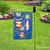 Briarwood Lane wrought iron garden flag stand holder in a garden with decorative flags displayed.