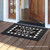Briarwood Lane Home Sweet Home Checkers doormat on a wooden porch with a printed decorative design.