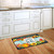 Briarwood Lane Happy Fall Pumpkins Primitive Doormat with colorful gourds, leaves on a kitchen floor.