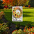 Briarwood Lane welcome flag with colorful floral sunflower wreath and checkered bow on a garden lawn.