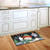 Briarwood Lane Snow Time Snowman printed doormat with knit hat and scarf on wooden floor.