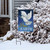 Briarwood Lane Christmas garden flag with white dove and olive branch on snowy winter porch display.