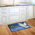 Briarwood Lane Peace on Earth Dove Christmas doormat on a kitchen floor, colorful holiday decor.