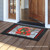 Briarwood Lane Christmas doormat with red pickup truck and labrador on a wooden porch floor.