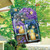 Briarwood Lane Fireflies Spring House Flag with purple flowers and lit candles in mason jars.