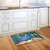 Briarwood Lane Crab Walk Summer Doormat on wooden floor in front of white kitchen sink area.