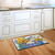 Briarwood Lane Rustic Sunflowers Summer Doormat on wooden kitchen floor beside white cabinets.