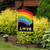 Briarwood Lane Rainbow Love Pride Garden Flag with colorful rainbow and love text on display outdoors.