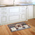 Briarwood Lane Rustic American Birdhouse Primitive Doormat on a wooden kitchen floor beside white cabinets.