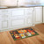 Briarwood Lane Fall Gnome Home Humor Doormat on kitchen floor with autumn leaves and pumpkins design.