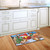 Briarwood Lane Barnyard Snowman Christmas Doormat on kitchen floor, colorful festive holiday printed decorative mat.