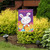 Briarwood Lane Easter Hatchlings Garden Flag with colorful bunny and chicks on purple background displayed outdoors.