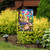 Briarwood Lane Spring Bunny Basket Garden Flag with colorful bunnies and flowers on display outdoors.
