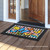 Briarwood Lane Checkered Butterflies Spring Doormat with colorful floral and butterfly design on wooden porch.