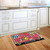 Briarwood Lane small printed doormat with colorful floral, butterflies, and checkers, reading welcome on kitchen floor.