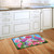 Briarwood Lane small printed doormat with colorful flowers, butterflies, and blue jay on kitchen floor.