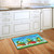 Briarwood Lane Happy Frogs Summer Doormat with colorful frogs, mushrooms, and dragonflies on kitchen floor.