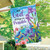 Briarwood Lane With God house flag with colorful flowers, birds, and inspirational quote on porch.