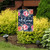 Briarwood Lane small, colorful, printed garden flag with floral spring design and welcome greeting on porch.
