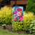 Briarwood Lane garden flag with colorful flowers, butterflies, and blue jay on a decorative yard display.