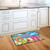 Briarwood Lane Hanging Flip Flops colorful doormat on wooden floor in front of kitchen sink area.