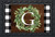 Briarwood Lane Wreath Monogram Letter G Doormat with green leaves on brown wood background.